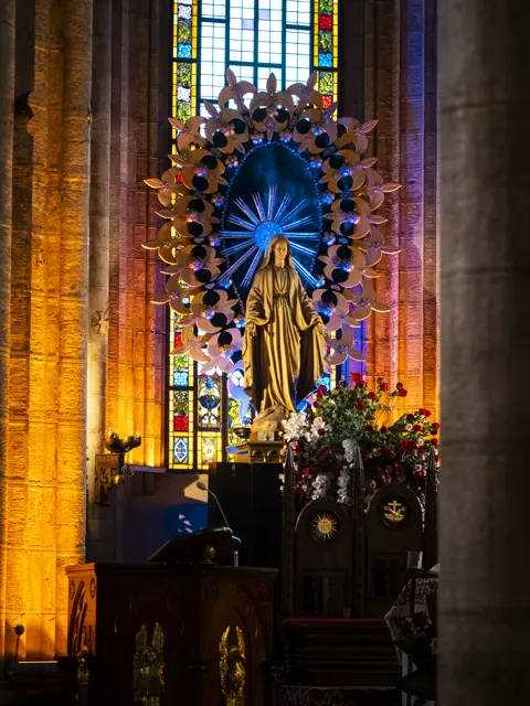 Church interior with stained glass and a golden altar