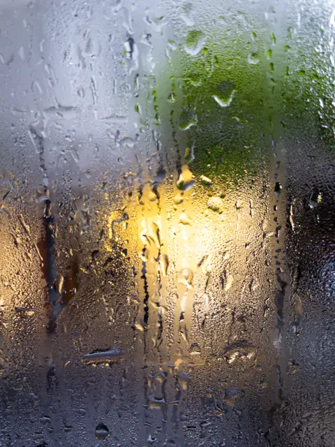 Raindrops on a window over blurred lights