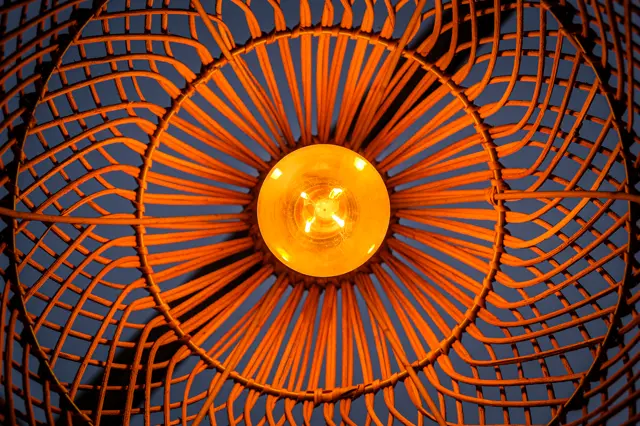 An orange fan grille glowing from behind