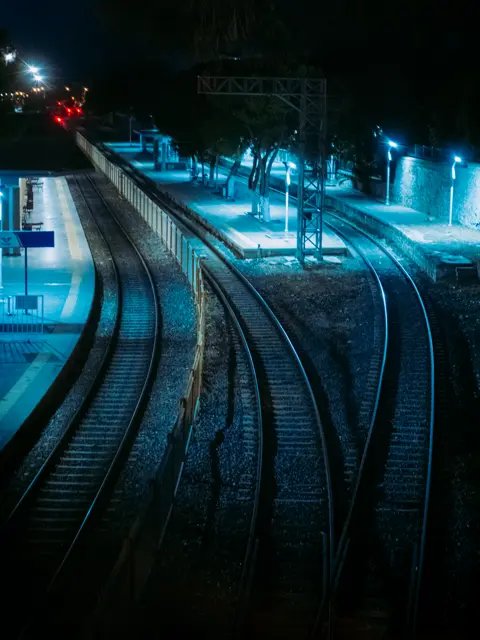 Railway tracks lit blue at night