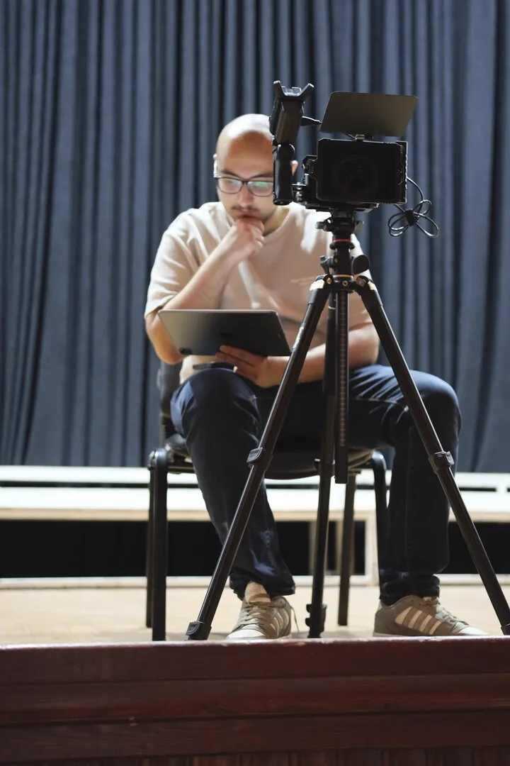 Reviewing notes on stage beside the camera